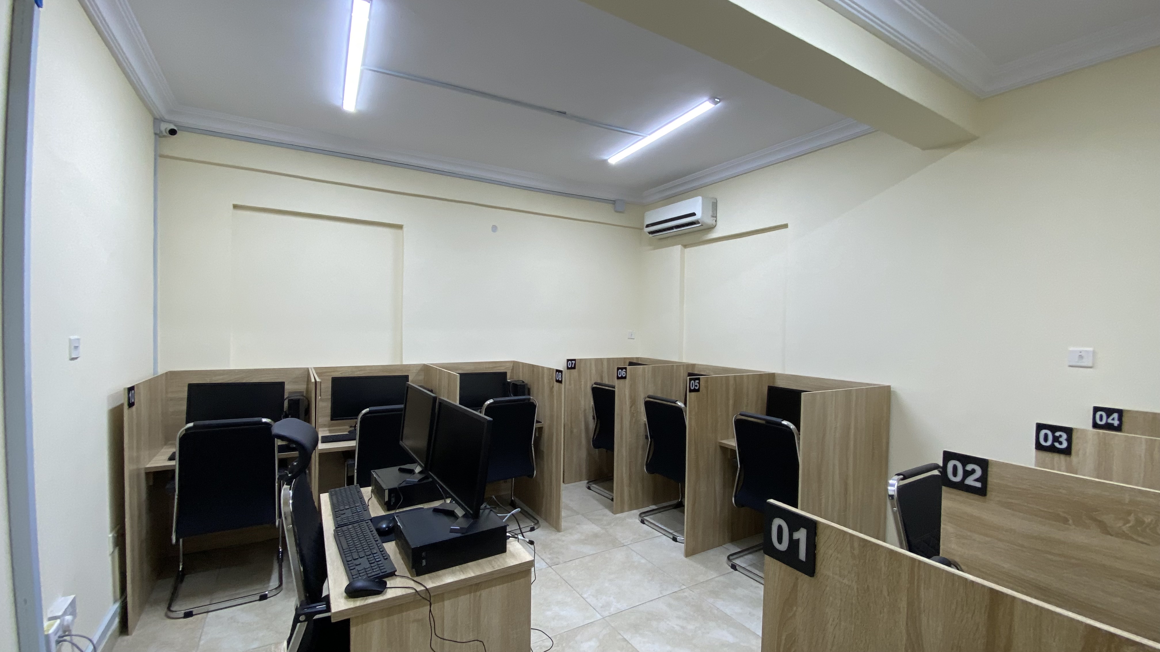 Examination hall at Befitting Hub with numbered computer workstations and privacy dividers