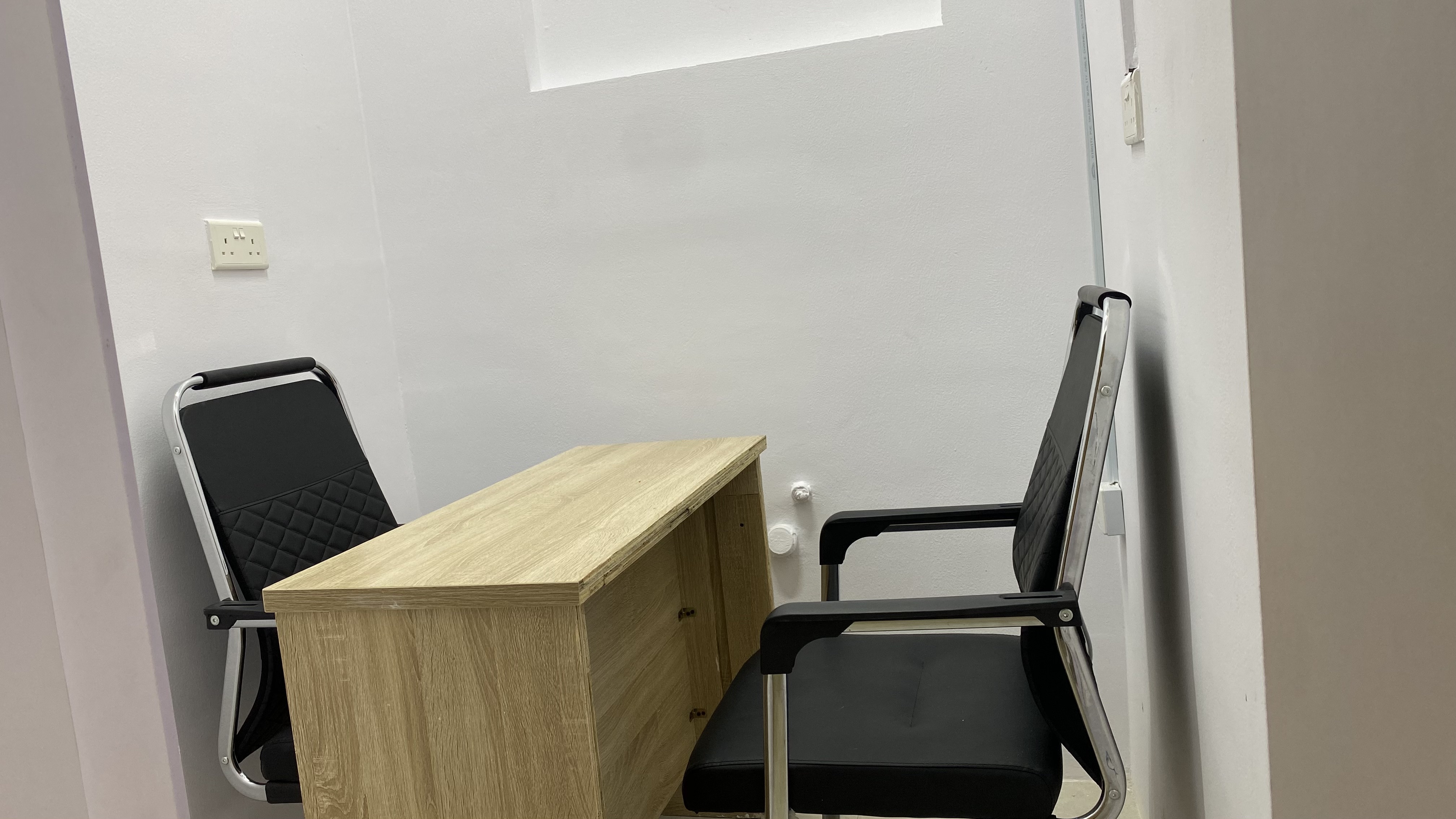 Private office desk at Befitting Hub with ergonomic chairs and bright lighting